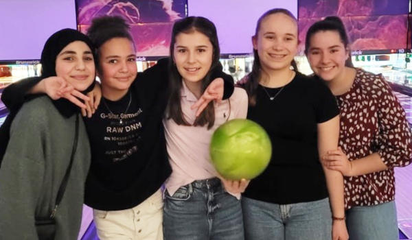Eine Gruppe von Schülerinnen auf einer Bowlingbahn