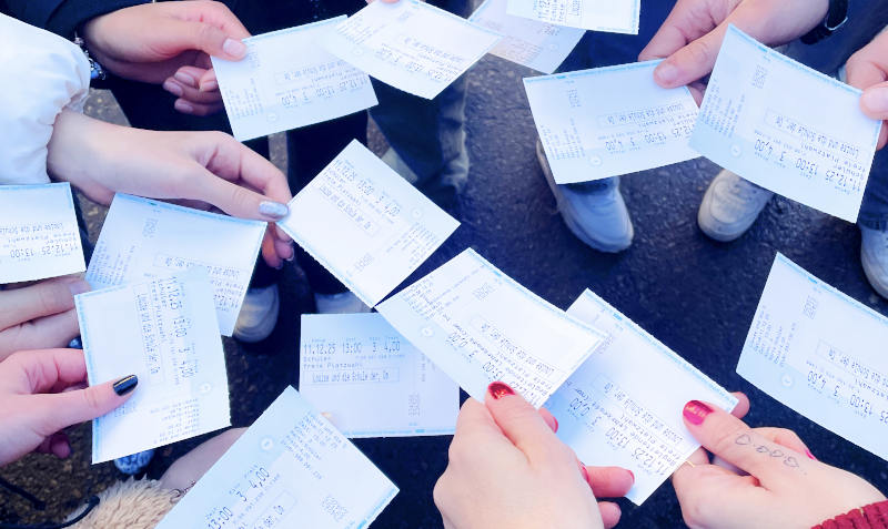 Schüler:innen halten Kinokarten in die Kamera.