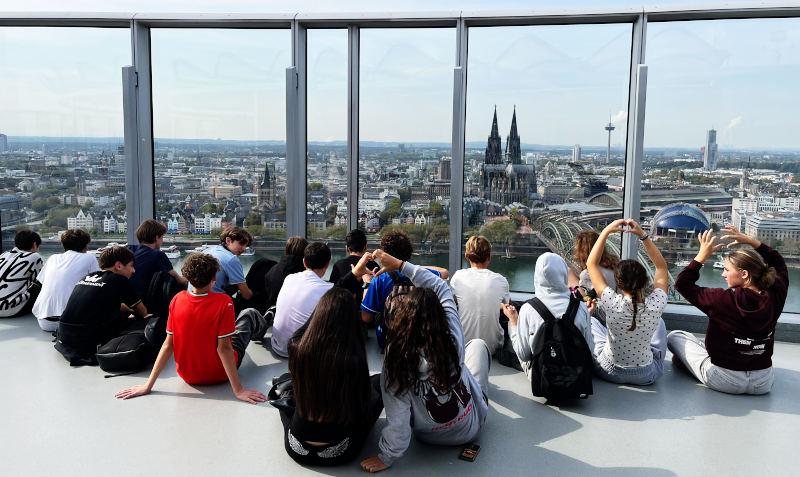 Schüler*innen vor und über dem Kölner Dom