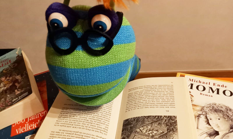Eine Stoffpuppe über Büchern